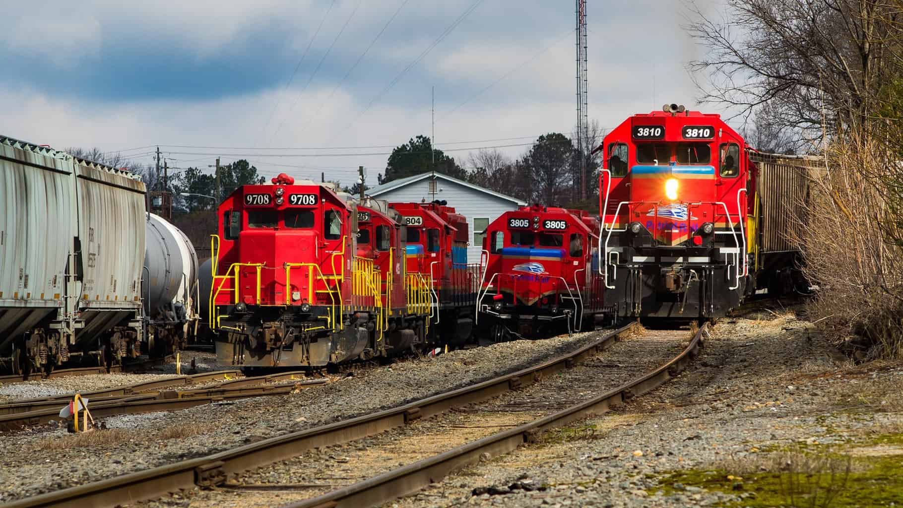 A photograph of Patriot Rail train at a rail yard.