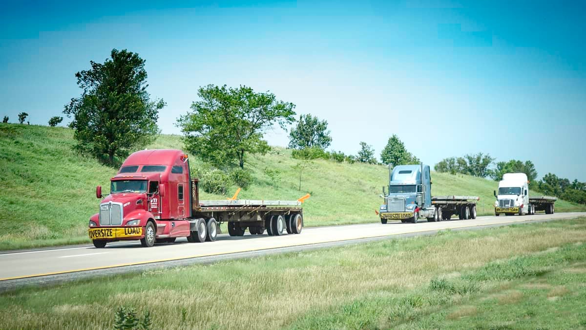 Flatbed trucks move down the road. (Photo: Jim Allen/FreightWaves)