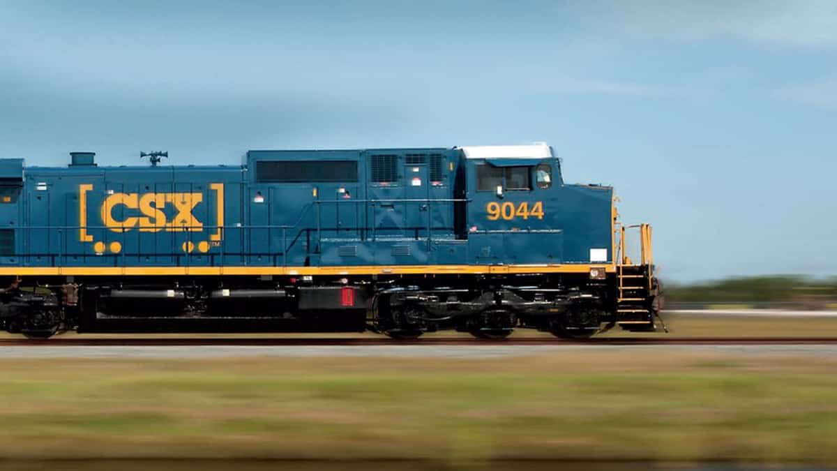 A photograph of a CSX train traveling through an open field.