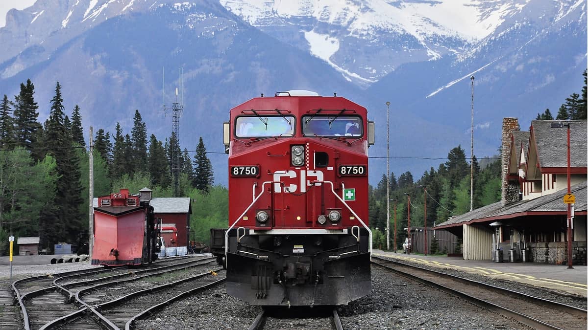 A photograph of a train with tall mountains in the background.