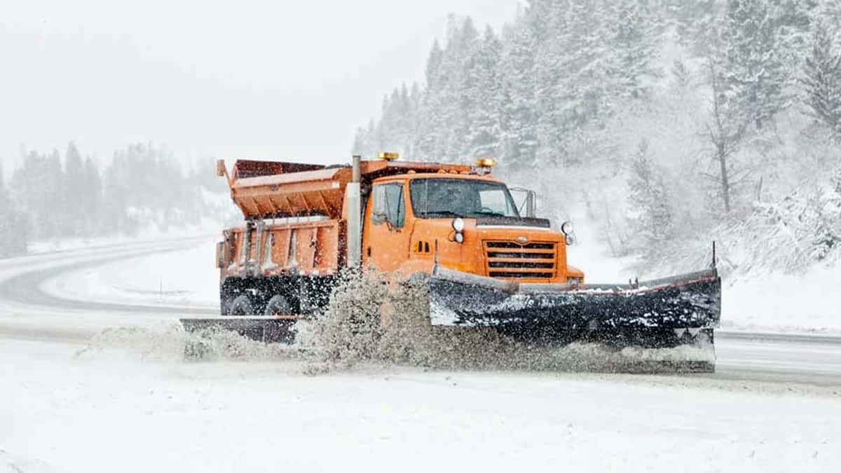 Plow truck clearing a snowy road.