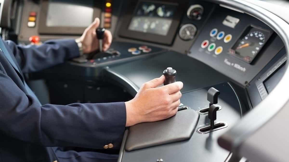 A photograph of a person at a driving console.