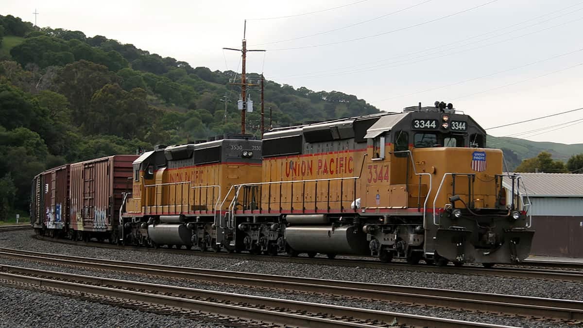 A photograph of a train hauling railcars on a railway track.