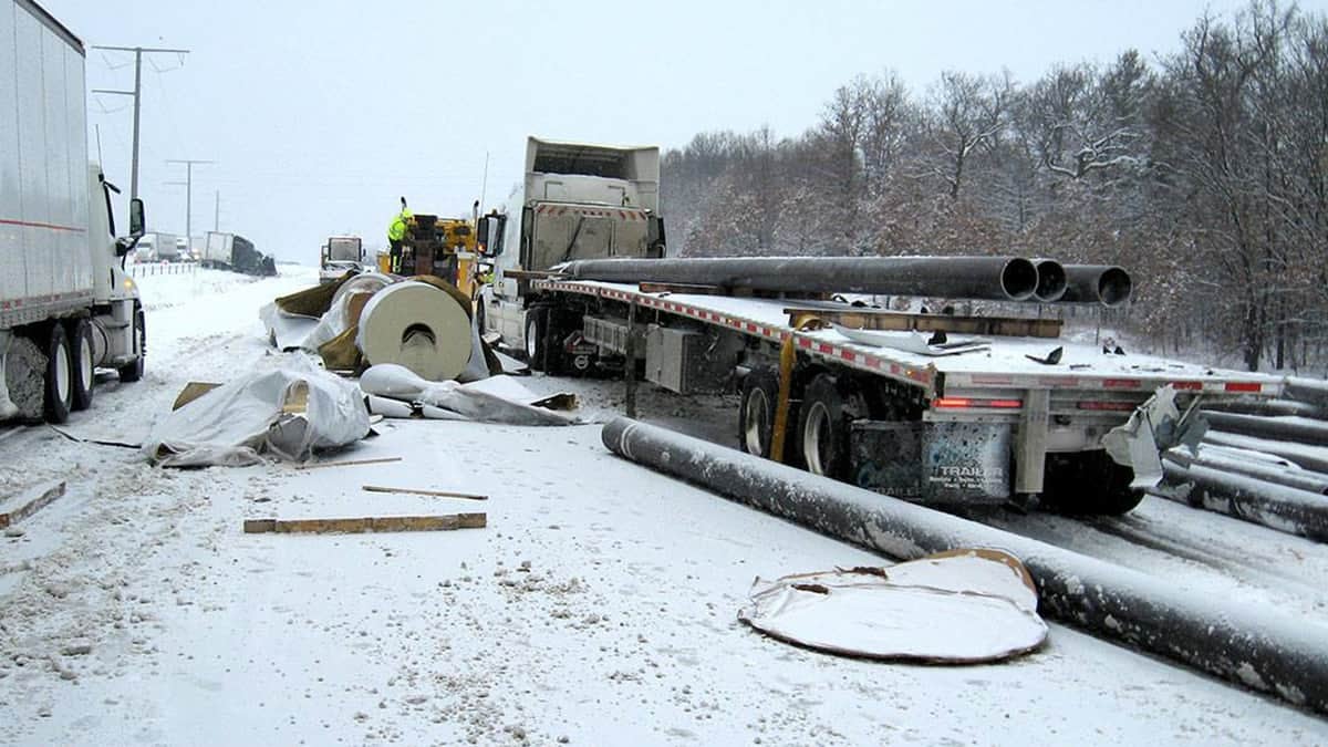 Flatbed truck accident on a snowy Wisconsin road.