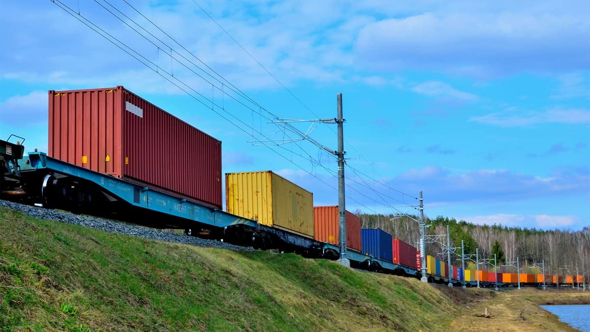 A photograph of intermodal containers on railway track that's on a hill.