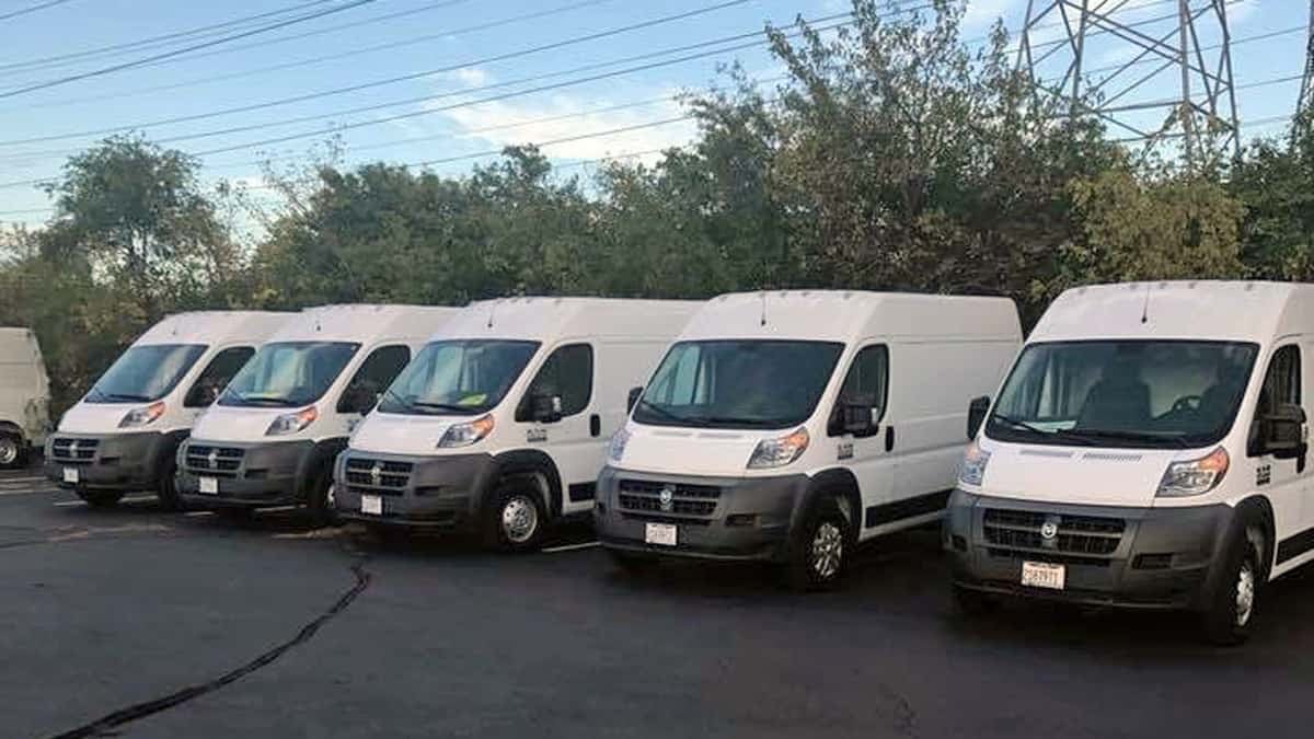 White delivery vans parked in a lot.