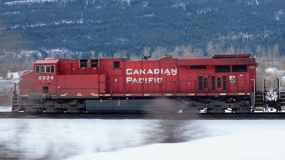 A photograph of a train traveling through a snowy field.