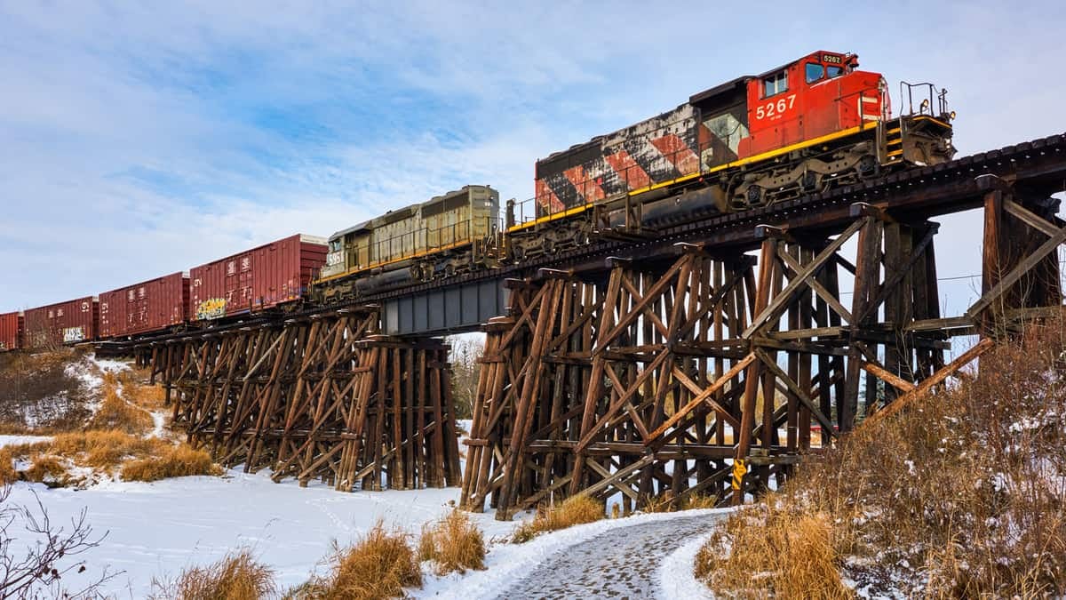 A photograph of a locomotive pulling railcars on a bridge.