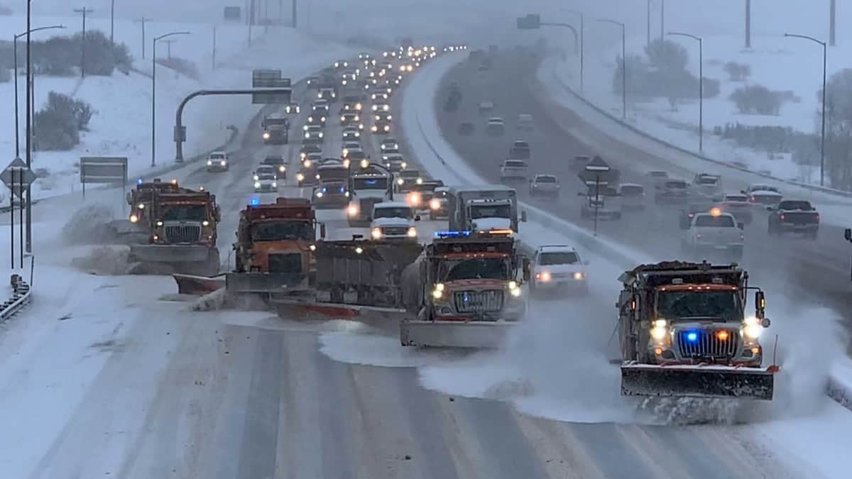 Plows clearing a snowy Colorado highway.