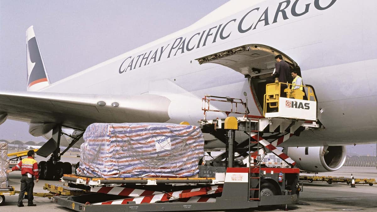 Big white plane with side cargo door open.