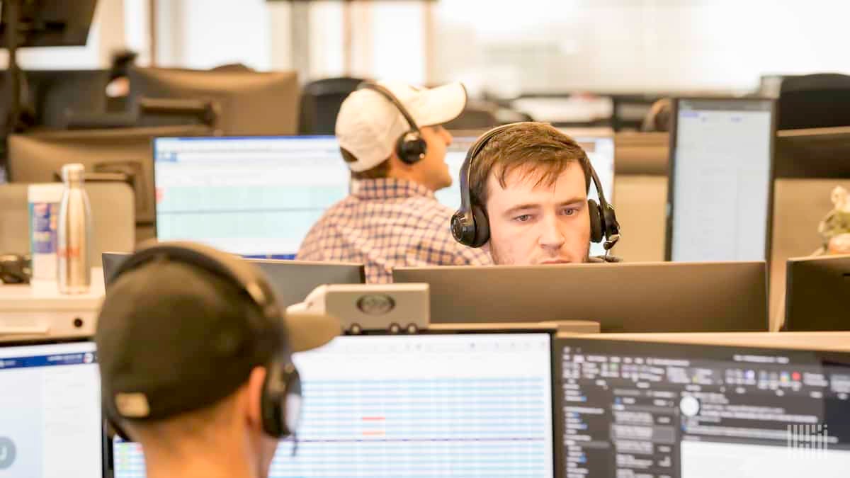 Man wearing headphones stares at computer screen