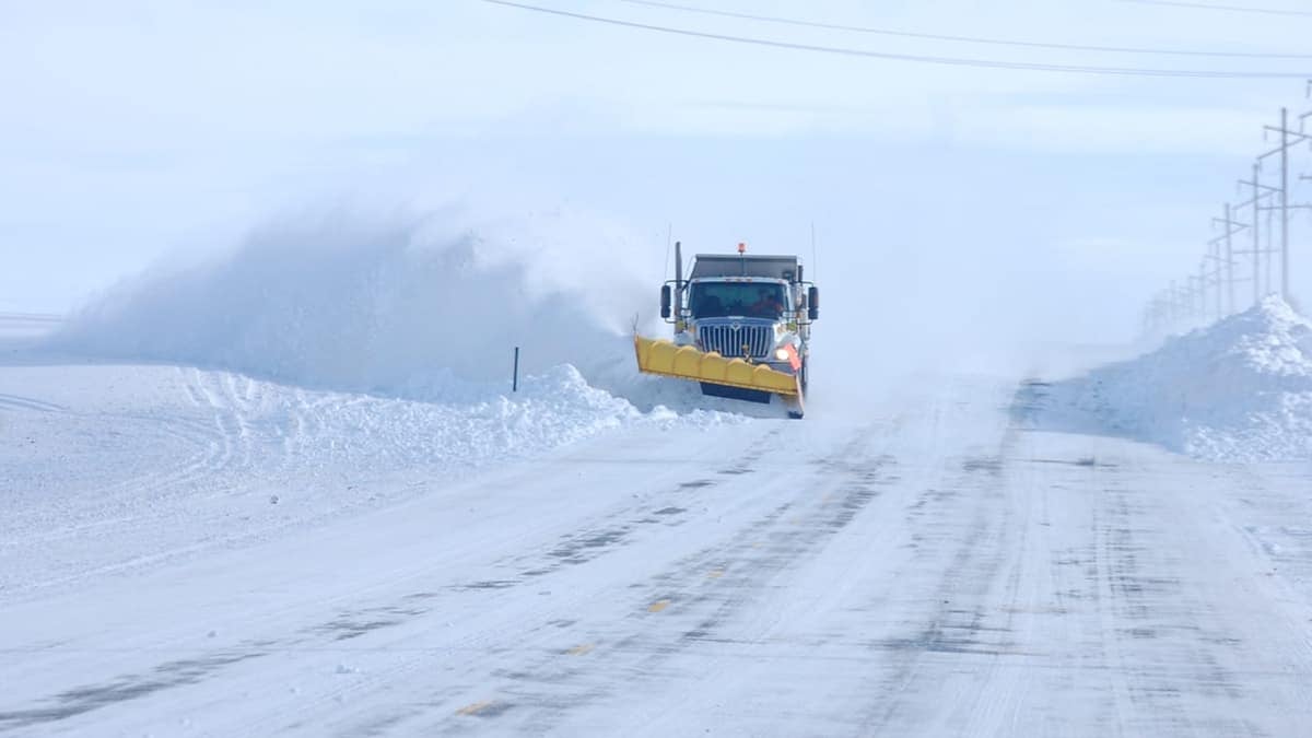 Plow clearing very snowy road in Idaho.