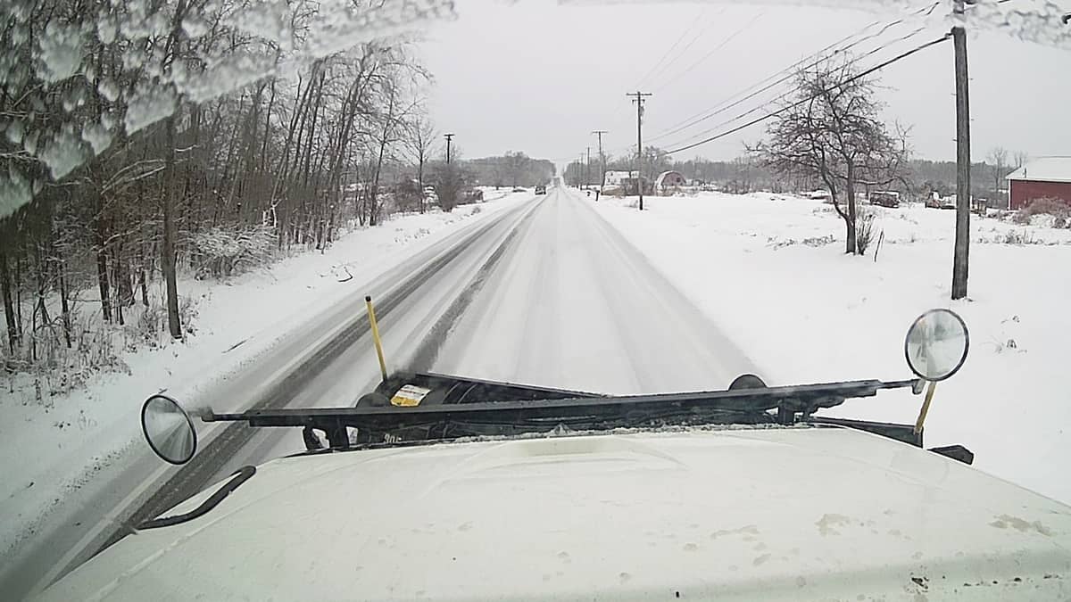 Plow clearing snowy Ohio road.