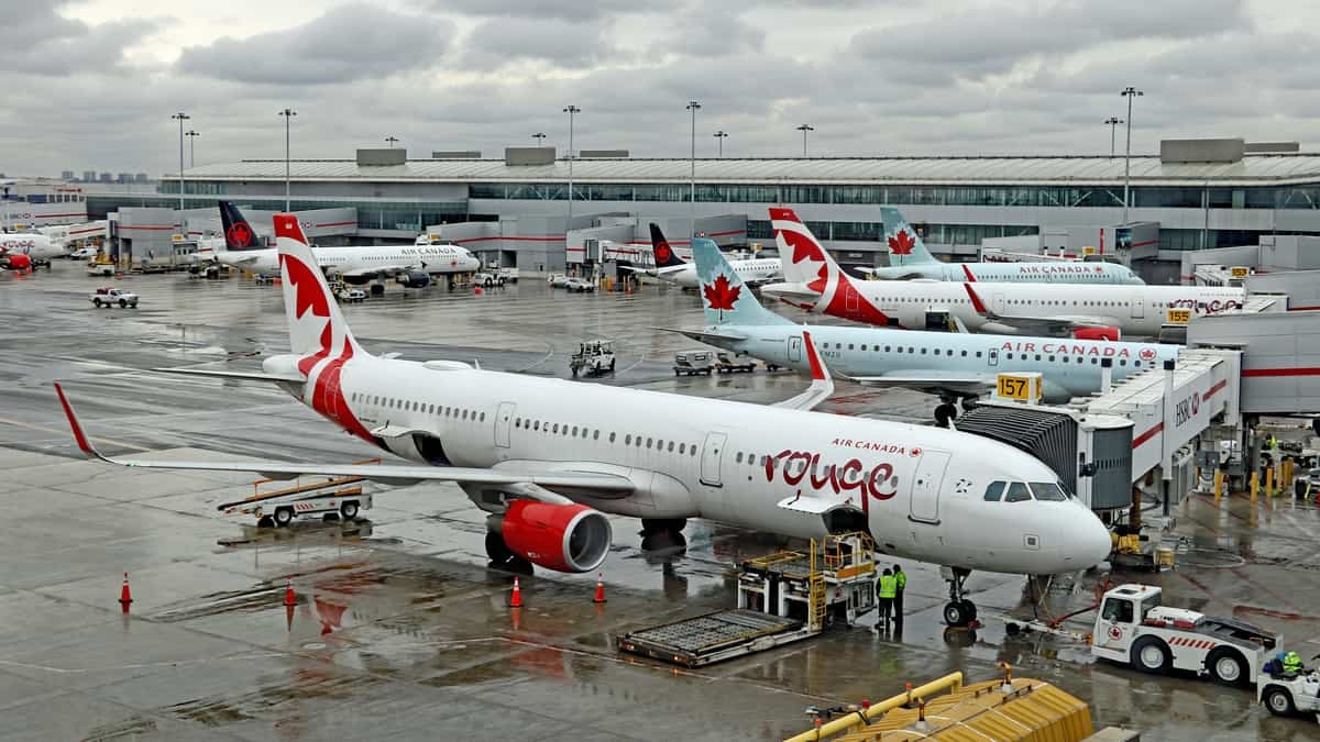 Air Canada planes at the airport gate on a rainy day.