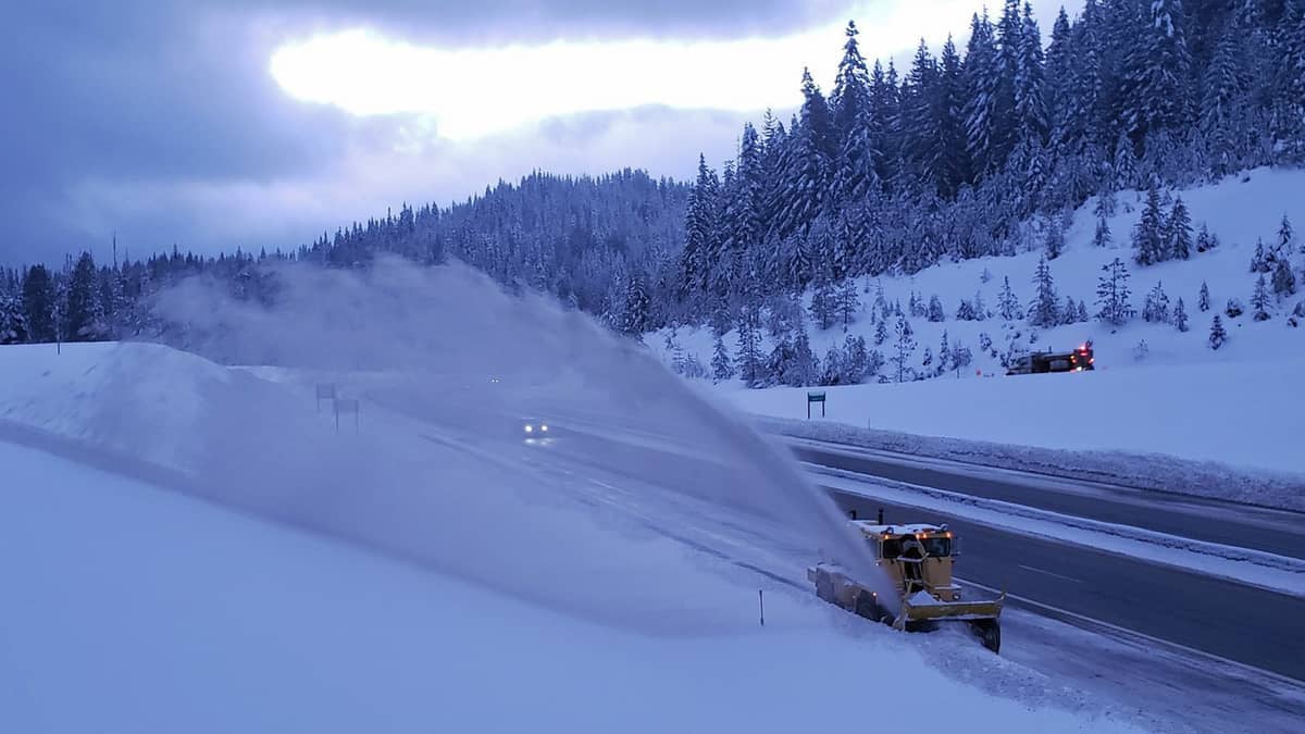 Plow clearing snowy highway in Idaho.