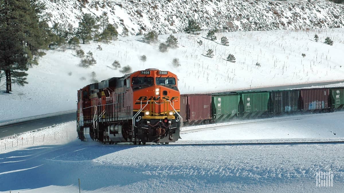 Freight train moving through a snow-covered landscape.