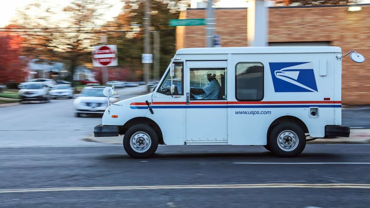 USPS truck driving down street