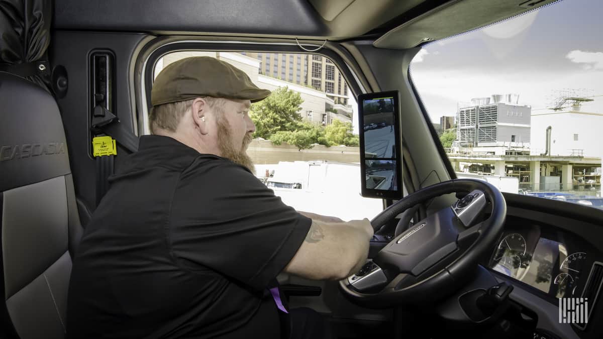 Truck driver using camera monitoring system to assist driving