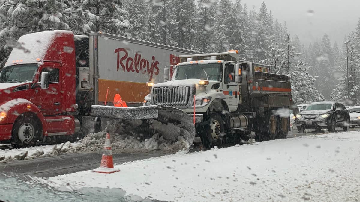 Tractor-trailer stuck on snowy road in the Sierra Nevada.