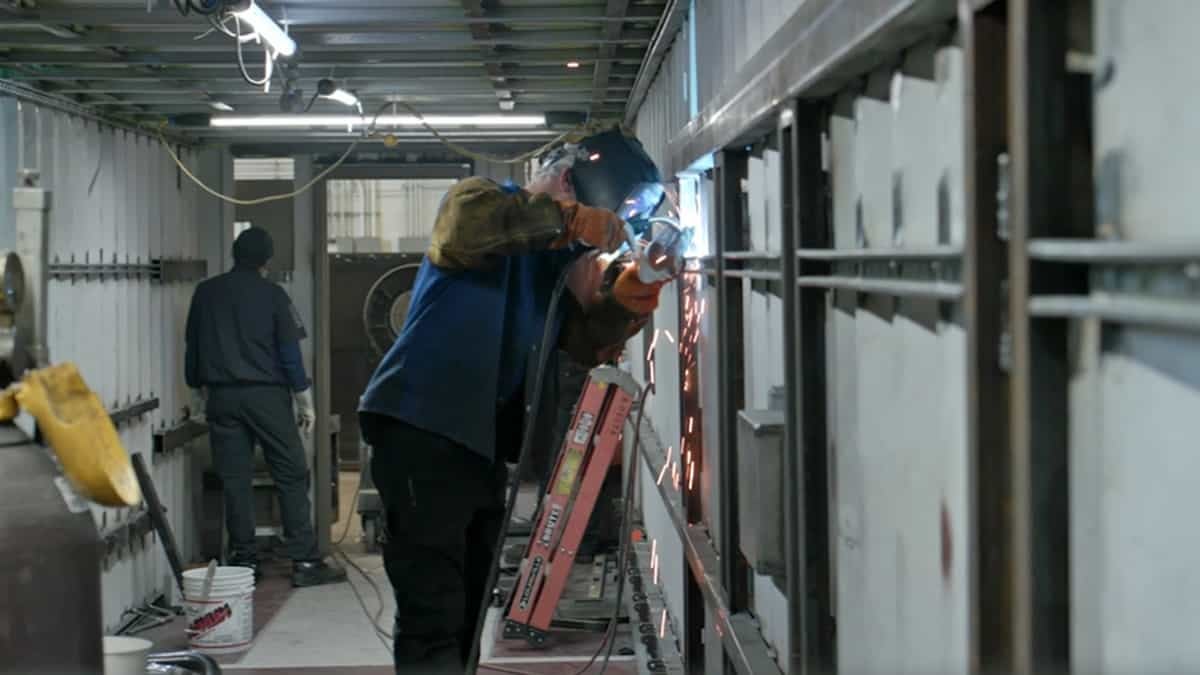 A welder inside a shipping container