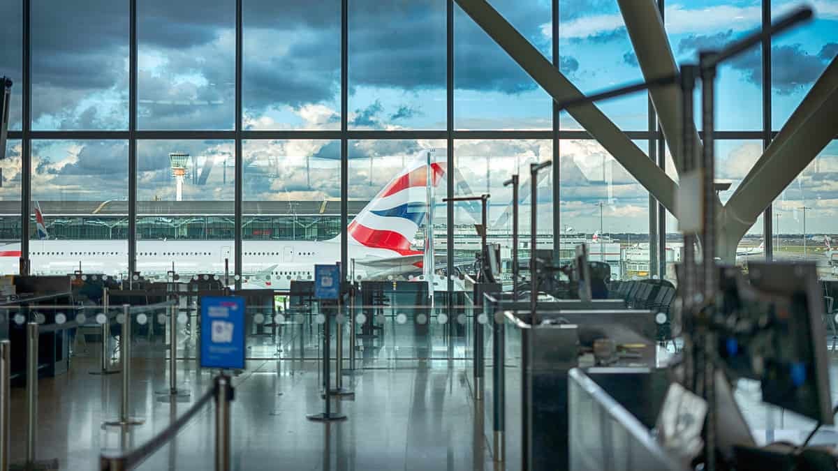 A large airplane seen through big glass window of airport terminal.