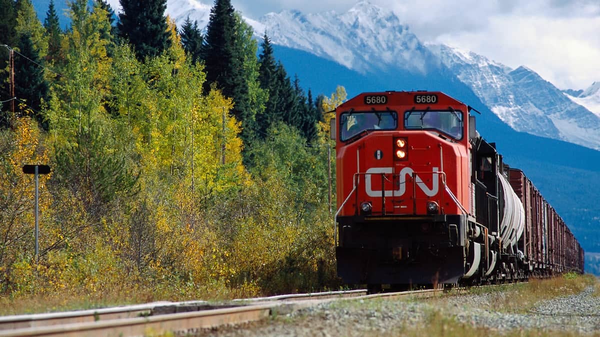 A photograph of a train. There is a mountain behind the train.