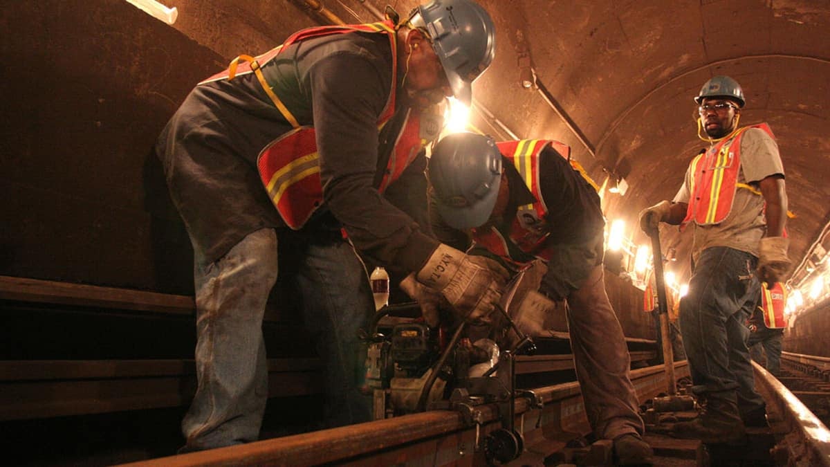 A photograph of workers fixing railroad track.