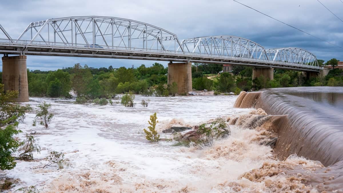 River flooding under a bridge.