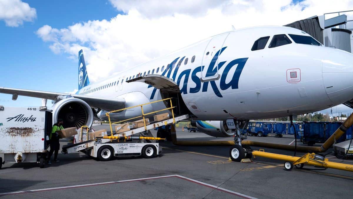 A white Alaska Air plane gets loaded through lower deck.