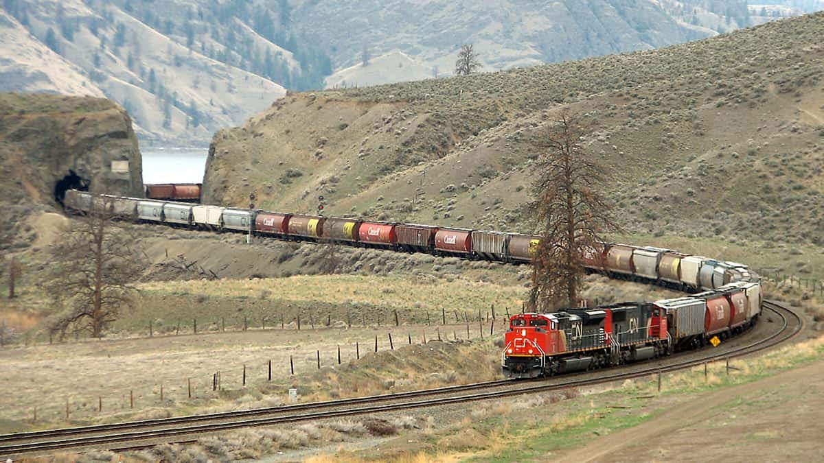 A photograph of a train hauling dozens of railcars behind it.