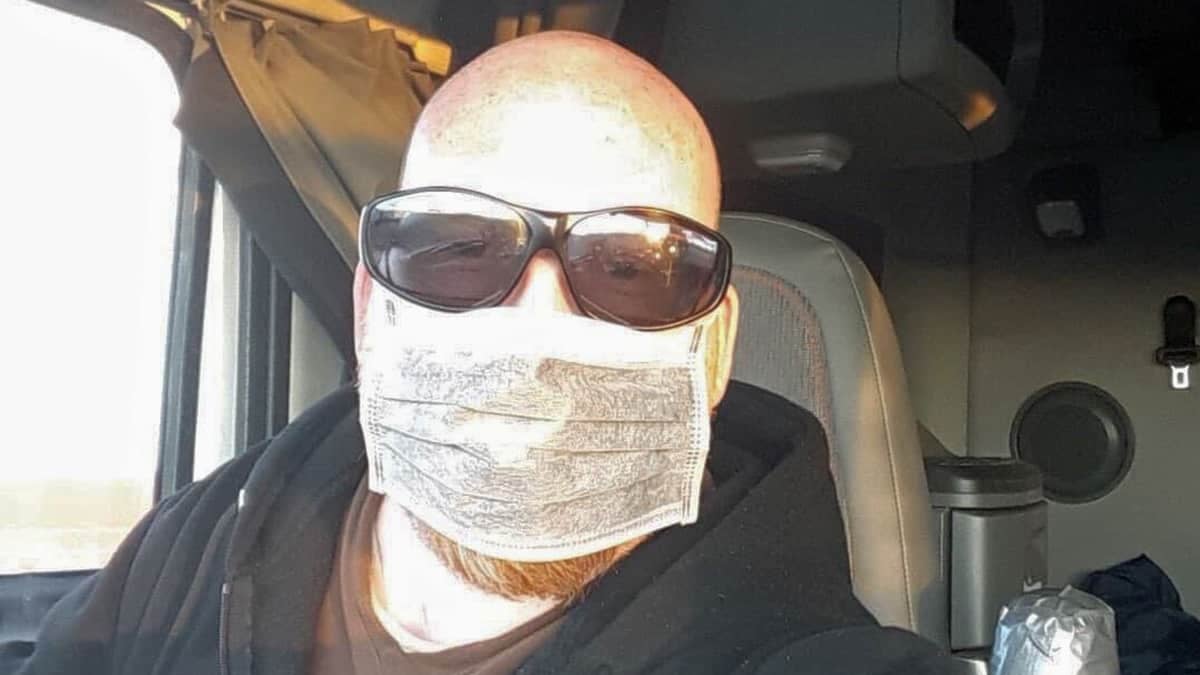 Canadian truck driver Randy James Ulch wearing a face mask in his cab