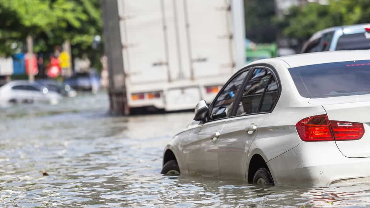 Tractor-trailer, car stuck in flood water.