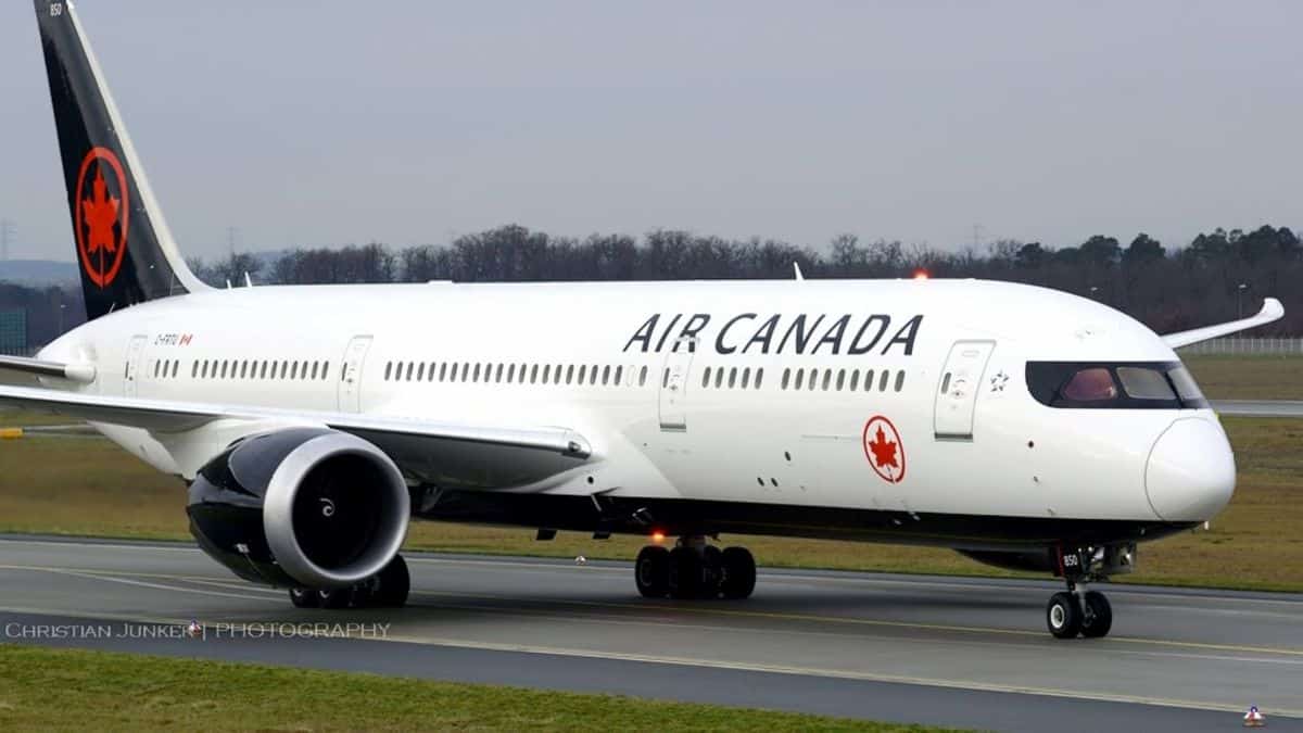 Big white Air Canada jet on runway.