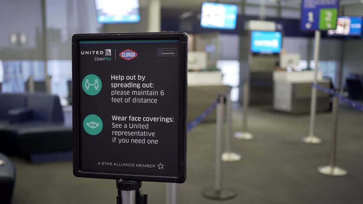 A sign at the ticket counter tells travelers to space out so they don't spread germs.