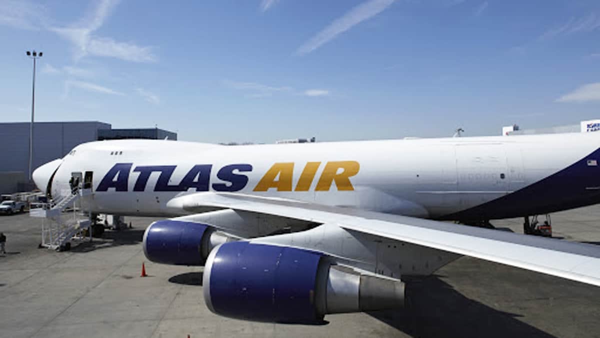 White jumbo jet sits on ramp at airport.