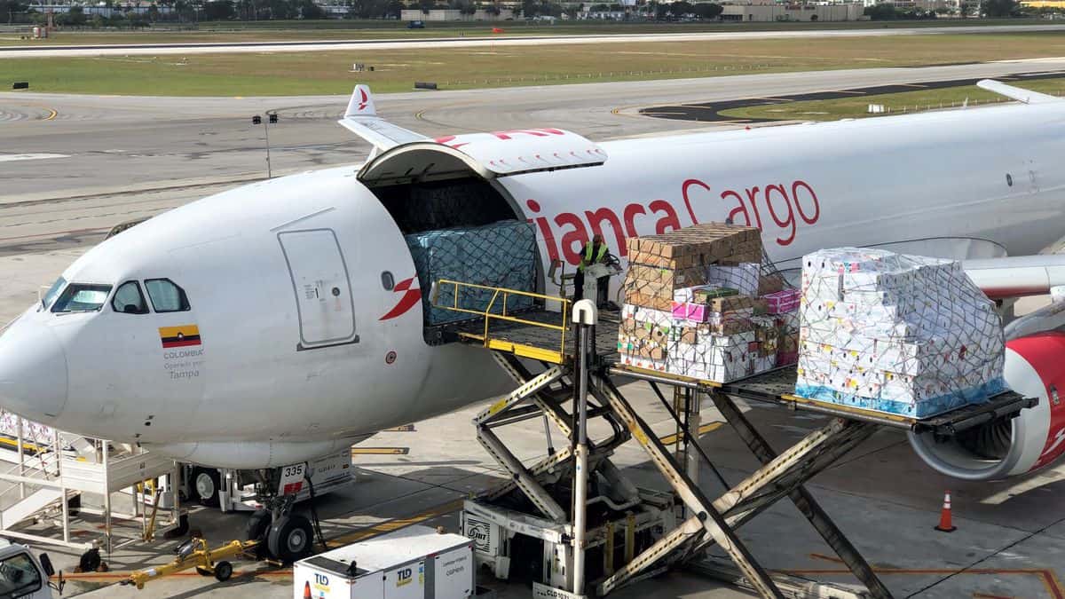 An Avianca white plane is being loaded with cargo.