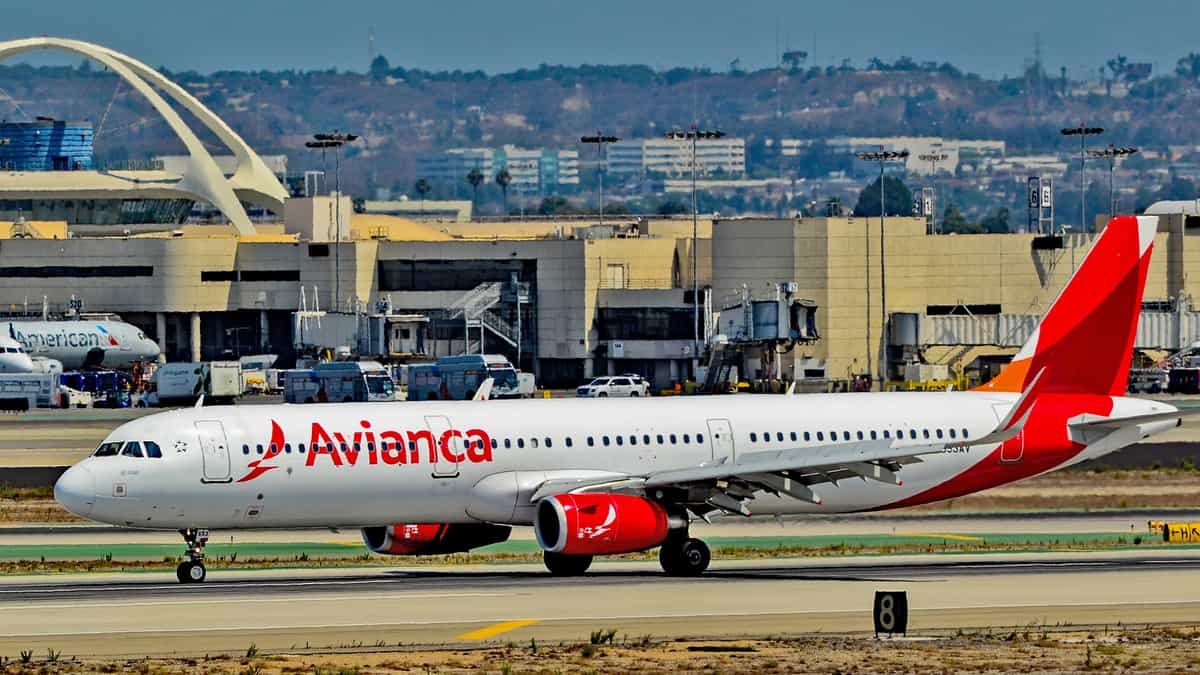 A white and red Avianca plane on the runway.