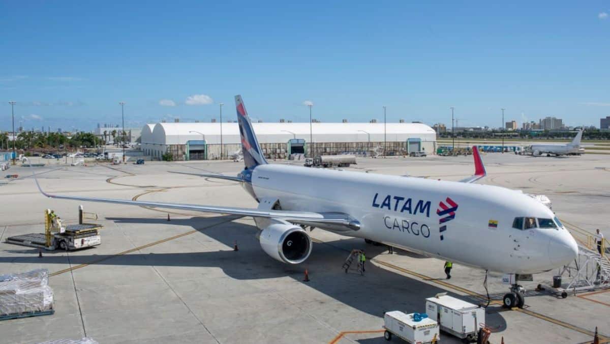 A white jet parked on airport ramp.