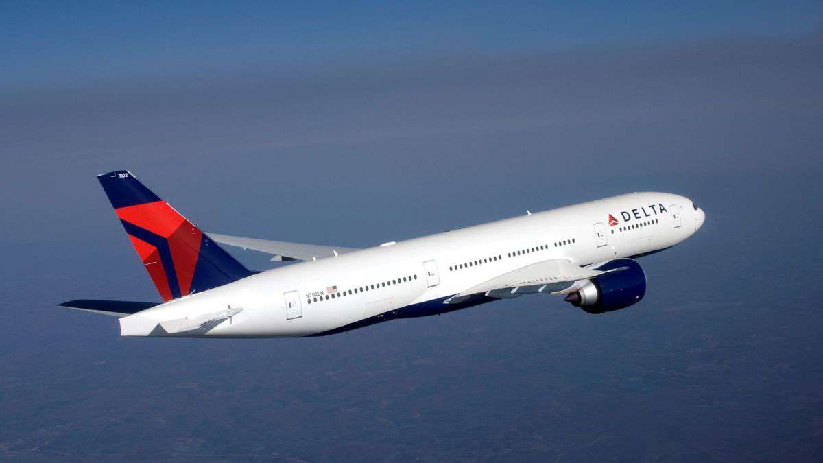 A white Delta plane crosses the sky.