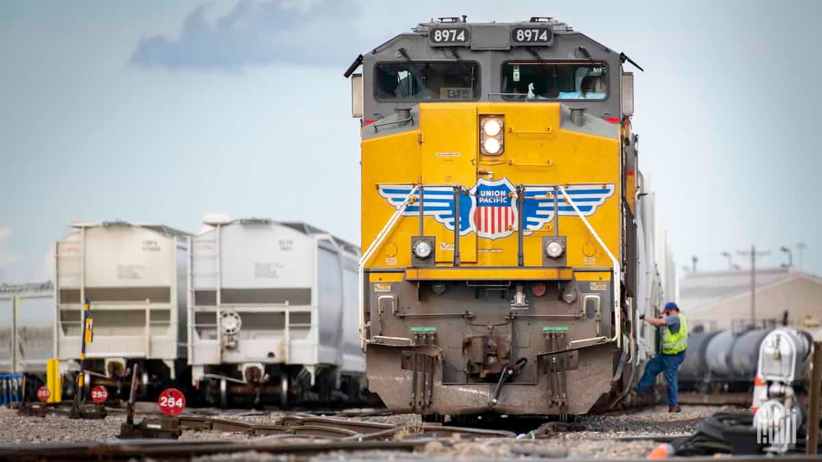 A photograph of a man boarding a freight train.