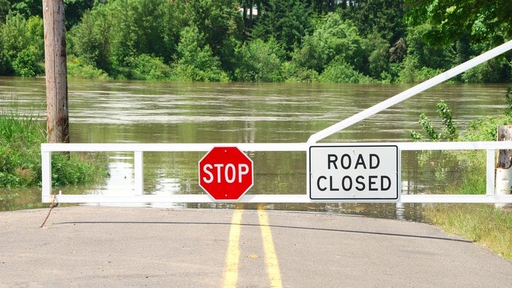 Flooded road with "Road Closed" sign.