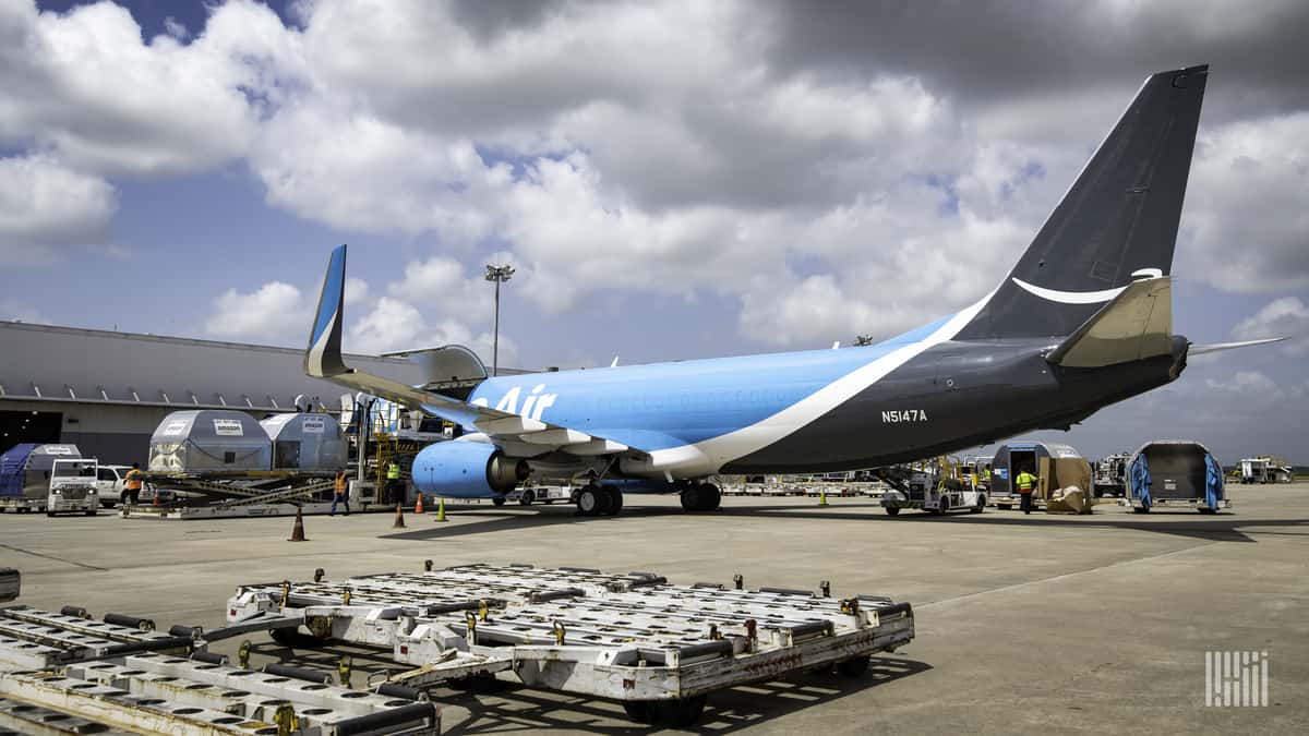 Light blue Amazon plane sits at gate waiting to be loaded.