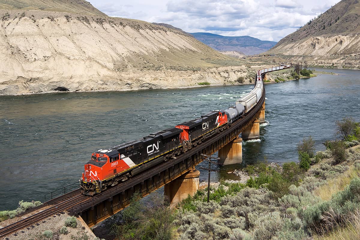 A photograph of a train on a bridge that's crossing a lake.