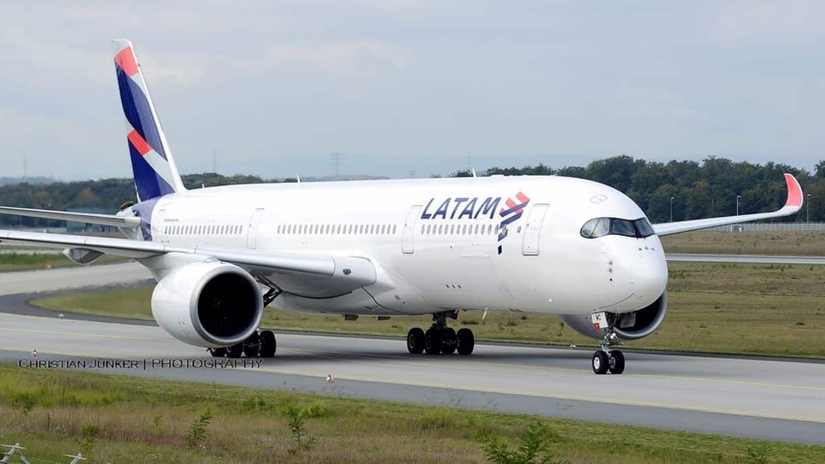 A big white jet with blue tail coming toward camera on taxiway.