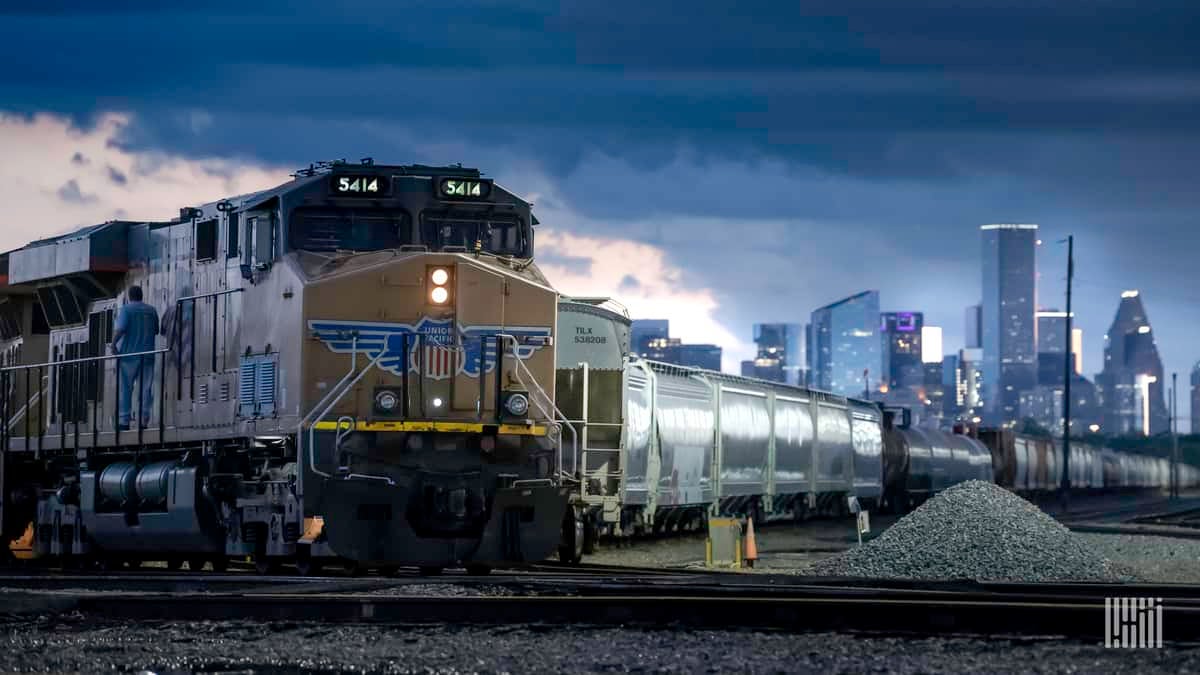 A photograph on a train with a city landscape behind it.