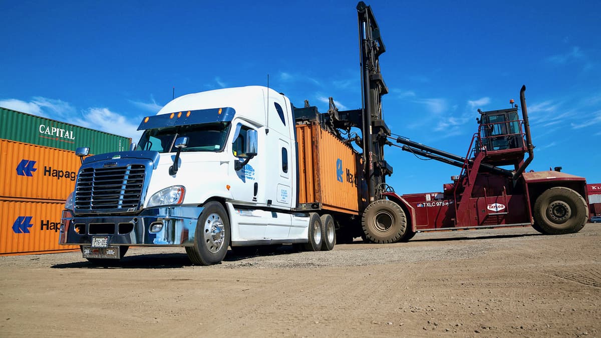 A shipping container is loaded onto a truck from Gusgo Transport, a Canadian trucking company recently acquired by TFI International.