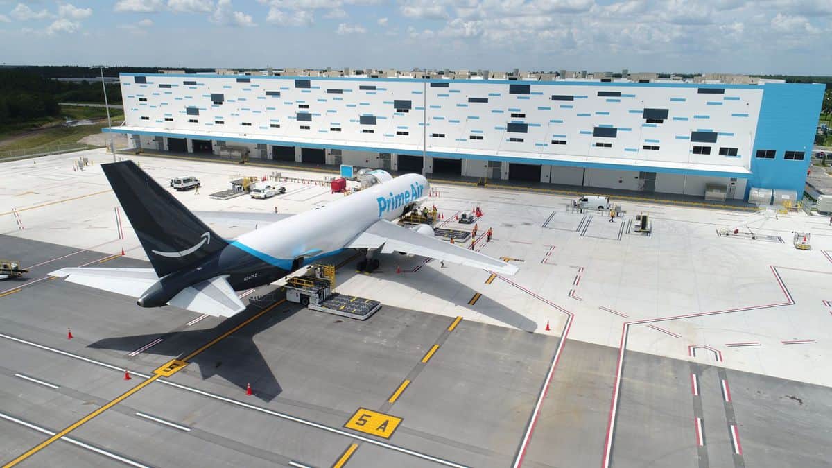 White Amazon jet with dark blue tail parked at new Lakeland, Florida, air hub, view from rear and above.