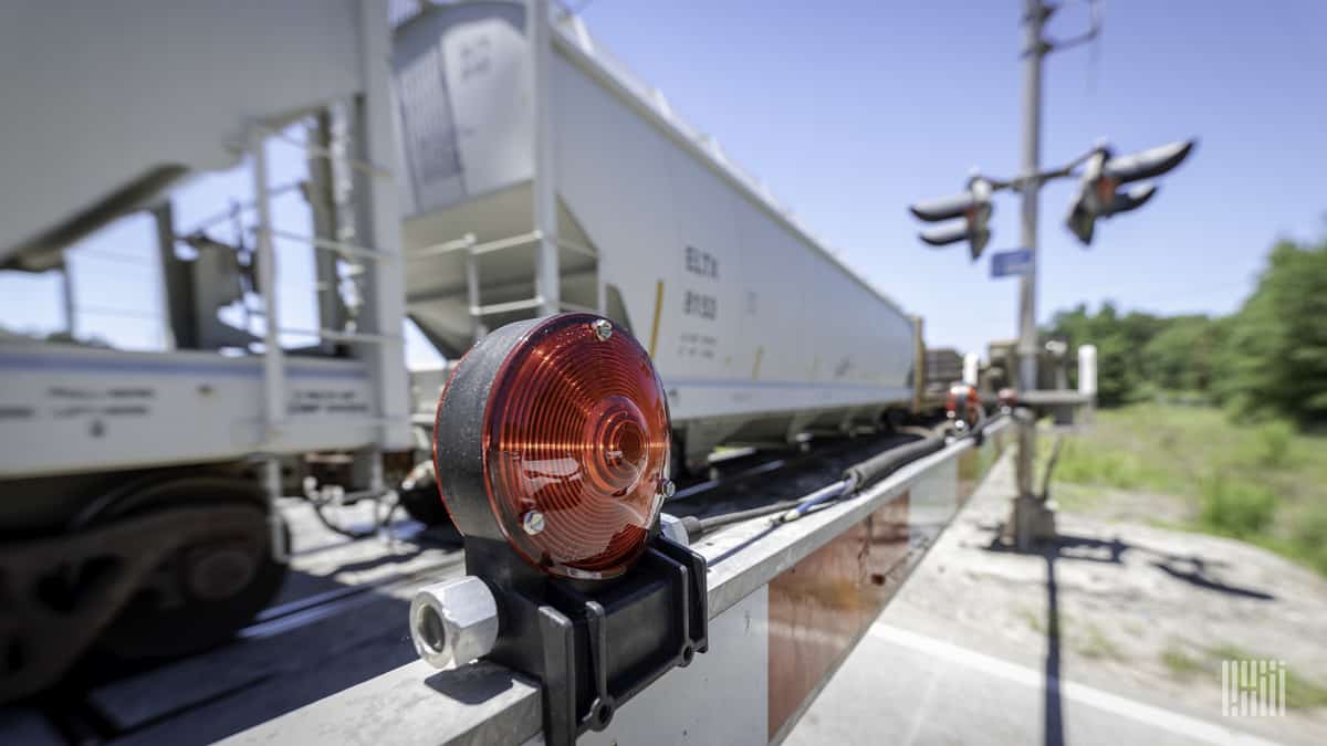 A photograph of a train at a railroad crossing.