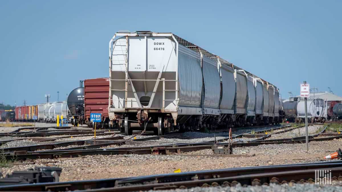 A photograph of a hopper car parked in a rail yard.