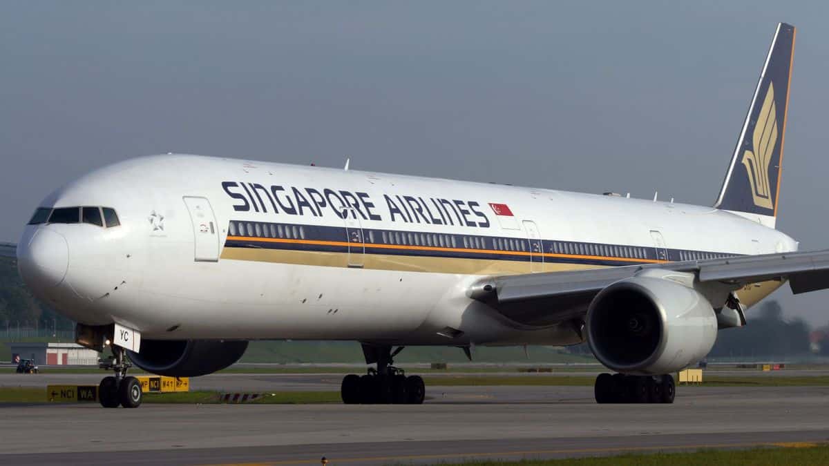 A big white Singapore Airlines plane, viewed at 45-degree angle from front as plane sits on ground.